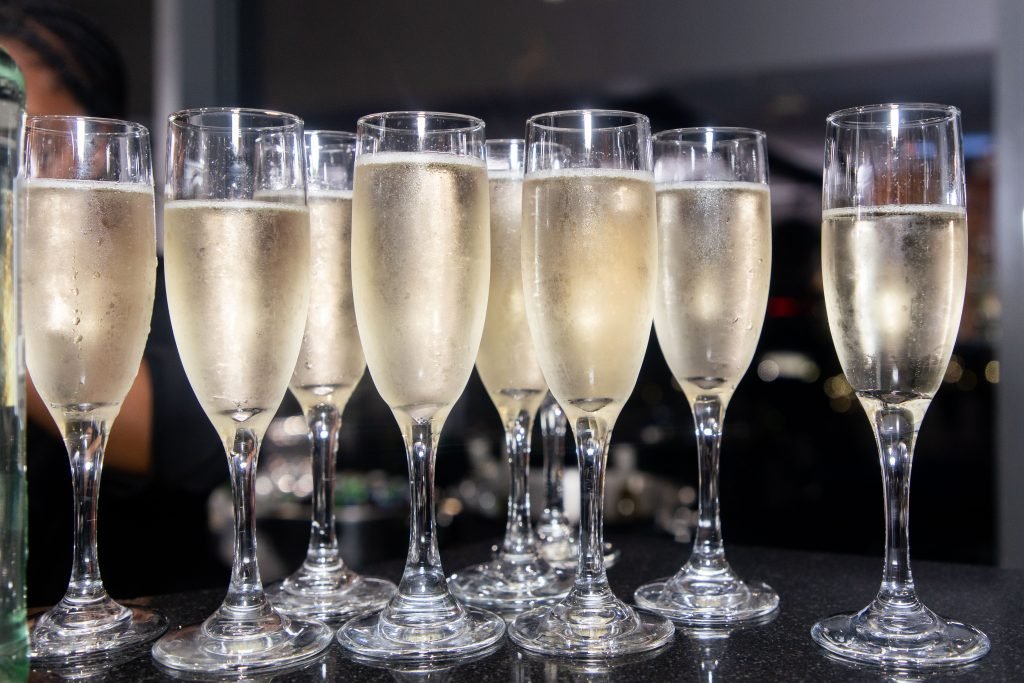 A close-up of champagne glasses lined up for a celebratory toast during an engagement party in Atlanta.