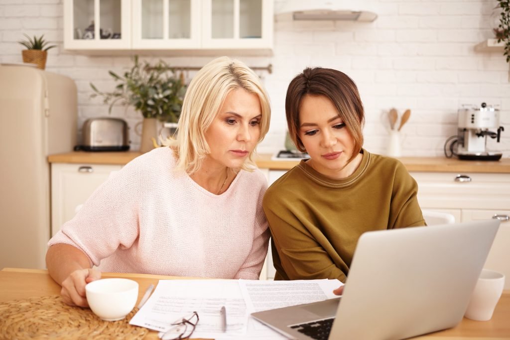 Mother and daughter happily discussing quinceañera ideas for an Atlanta celebration using a planning workbook
